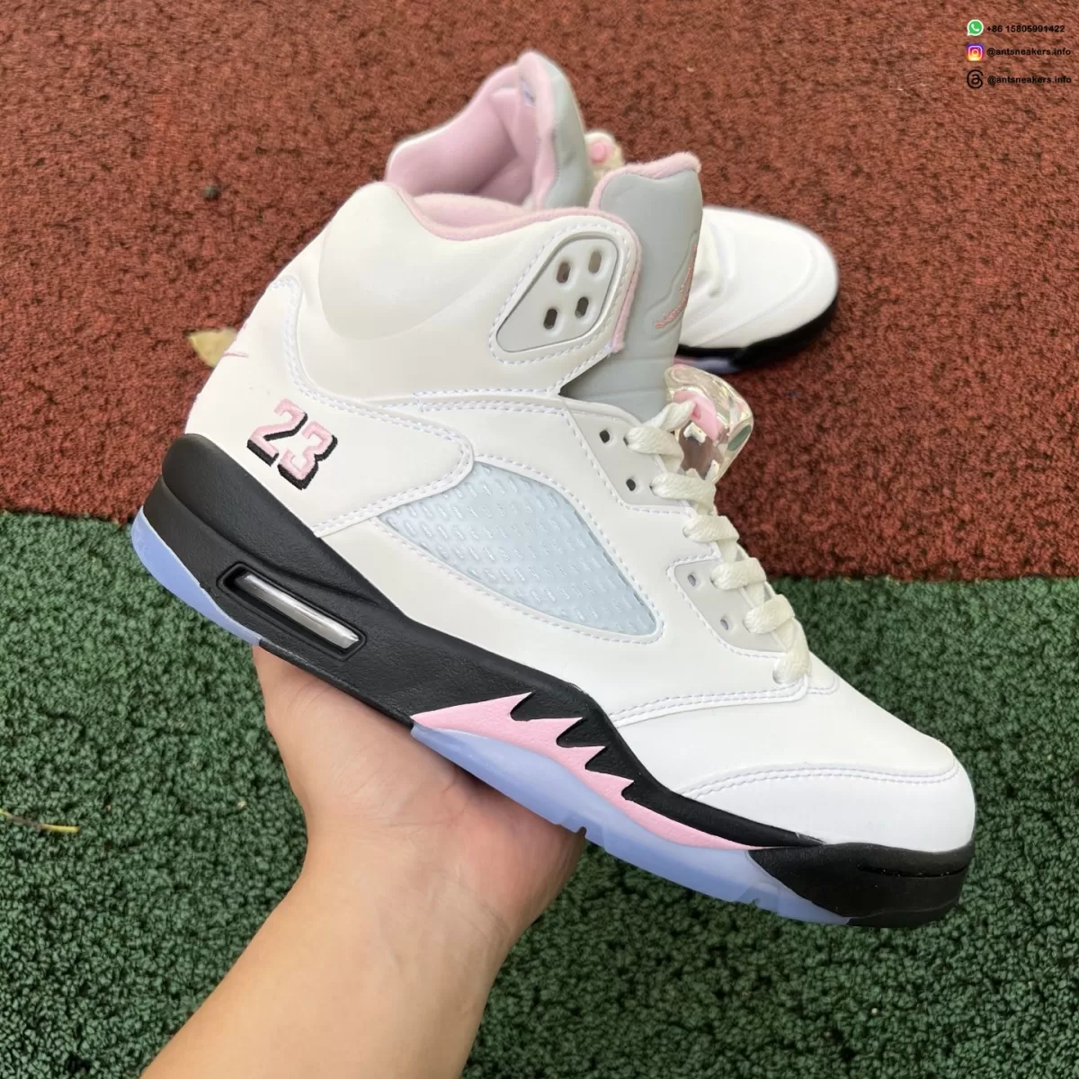 HQ7978-102 hand-held side view with a black midsole, pink jagged accent and pink 23 embroidery